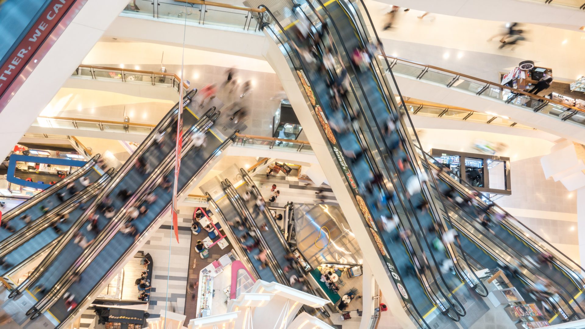 Bangkok, Thailand – Oct 23, 2019: Top view motion blurred of crowded Asian people using escalators in modern shopping mall. Asia city life, shopping lifestyle, commuter transportation concept